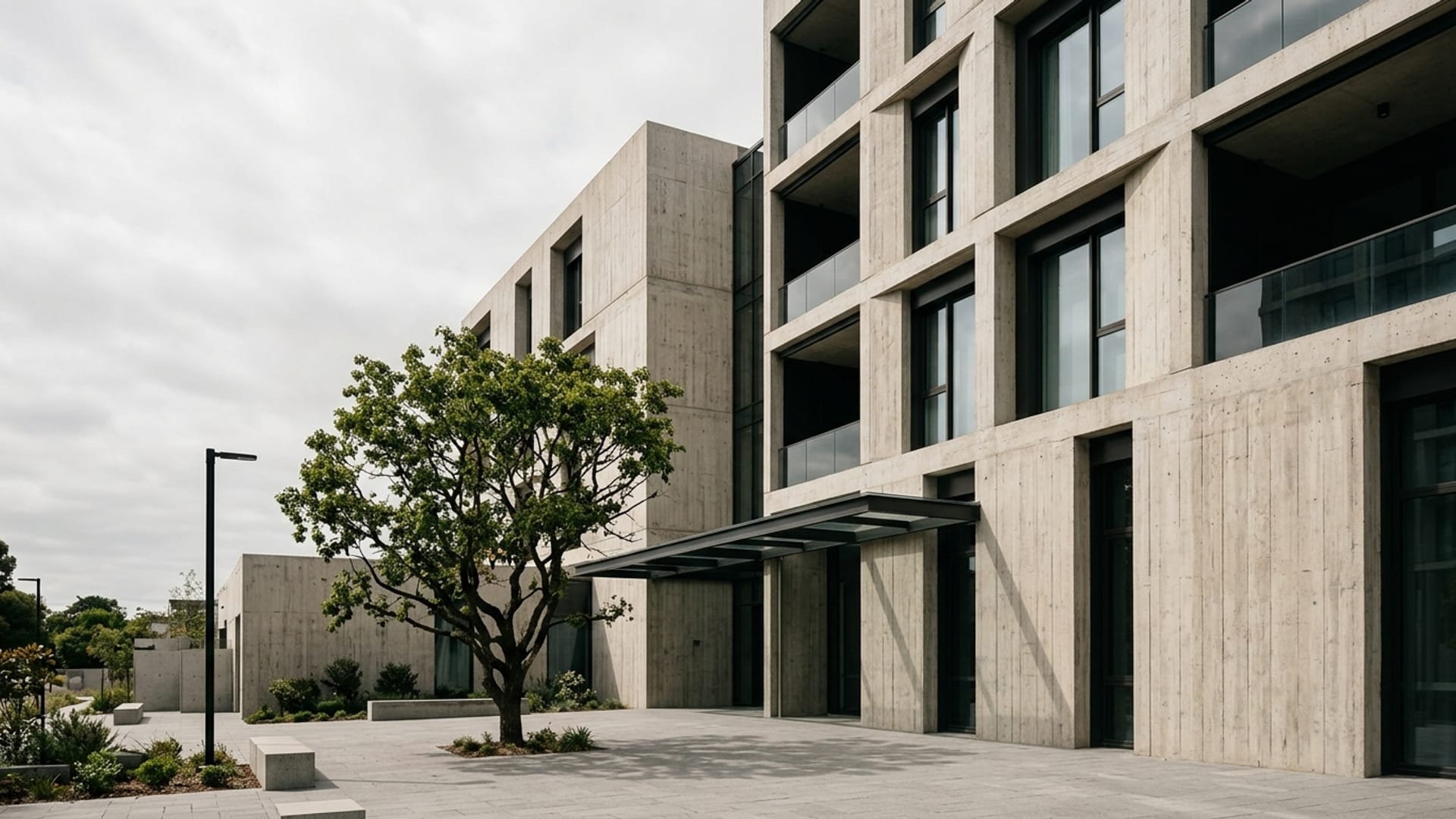 Board-formed concrete and glass facade of a contemporary building in overcast daylight